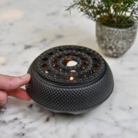 Scale Shot of Black Oriental Cast Iron Teapot Warmer