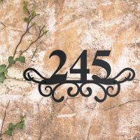 Traditional Iron Ornate Number Sign on a Rustic Wall