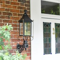 Black Victorian Wall Light With Brass Bar Decoration Installed Outside Porch