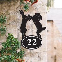 Boxing Hares Iron House Number Sign on a Garden Wall