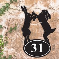 Boxing Hares Iron House Number Sign in Situ a Rustic Wall