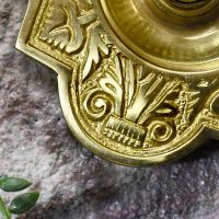 close up of ornate casting detail on polished brass bell push