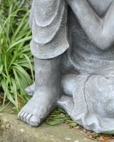 Close up of feet detail on sitting buddha garden sculpture