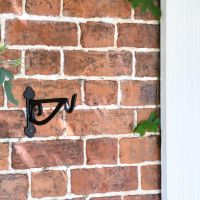 Black Scroll Iron Hanging Basket Bracket on Brick Wall