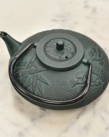 Dark Green Cast Iron Teapot With Handle Down and Lid On 