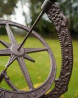 Close up of arrow detail on rustic finish garden armillary