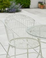 Close up of ornate chair backrest detail on garden bistro set
