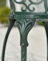 Close up of ornate chair leg detail in two seater garden bistro set
