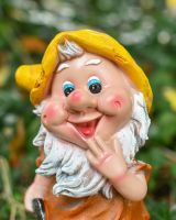 Close up of intricate face detail on colourful garden gnome ornament