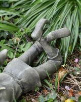 Close up of crossed legs and feet detail on resin garden statue