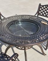 detailed close up of dining table with firepit bbq centre 