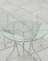Close up of glass table top detail on outdoor two seater table and chairs set