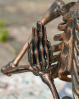 Close up of intricate hand detail on skeleton garden statue