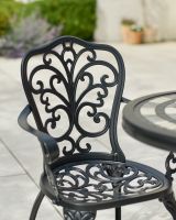 Close up of ornate chair backrest detail on two seater patio furniture set