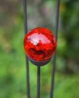 Close up of red suncatcher marbel detail on plant pot stake