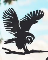 Close up of intricate cut out detail on black flying owl tree spike
