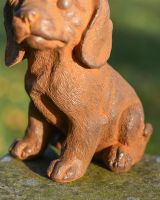 Close Up of Sitting Dog Garden Sculpture On Wall