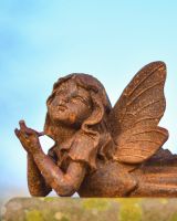 Close up of face and bird detail on rustic finish garden ornament