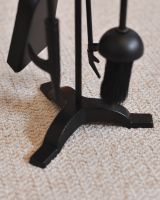 Close up of freestanding base on black fireside companion set