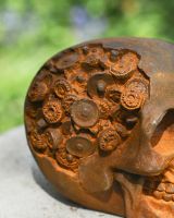 Close up of cog detail on rustic finish garden statue
