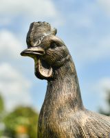 Close up of intricate face detail on rooster garden statue