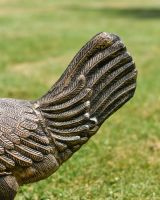 Close up of intricate tail detail on cockerel garden statue