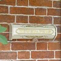 Cream Newspaper Holder Mounted On Brick Wall
