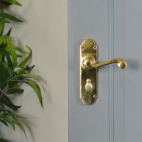 Polished Brass 6 Inch Lever Lock Handles on Grey Door in Situ