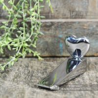 Chrome Chubby Heart Door Wedge Next to a Door