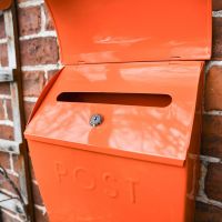 Close up of lockable aperture on Orange Post Box 
