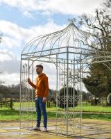 Scale Shot Man Next To Cream Gazebo 