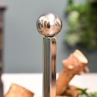 Detailed imago of ball finial on simplistic fire grate fire dog