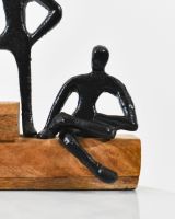 Close up of cast aluminium figure on mango wood block interior ornament