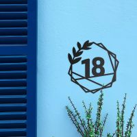 Geometric Leaf House Number Sign on a Blue Wall