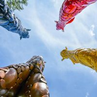 Below from standing between colourful giraffe sculptures