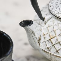 Close Up Of Gold & White Cast Iron Teapot Spout