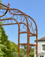 Close up of ornate scroll work on rustic rose arch