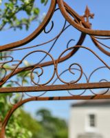 Close up of intricate scrollwork on rustic garden arch