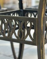 Close up of ornate table leg detail on antique bronze garden dining table