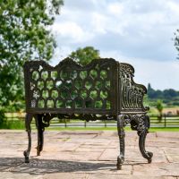 Rear view of Ornate Aged Black Garden Bench in Situ 