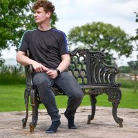 Ornate Black Ornate Cast Iron Bench with Male for scale 