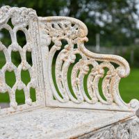 Close up of Antique Cream Cast Iron Garden Bench