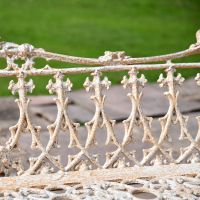 Close up of Antique Cream Cast Iron Gothic Garden Bench