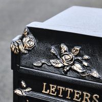Close up of floral and rose detailing on post box 