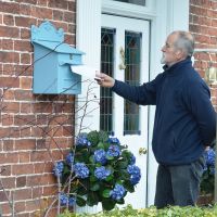 post in parcel box on wall finished in light blue