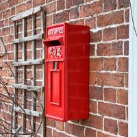 Side view of Red Redford Keep King George Post Box Mounted to Wall 