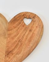 Close up of cut out heart detail on natural wood serving platter