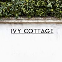 Minimalist House Name sign Black on garden wall