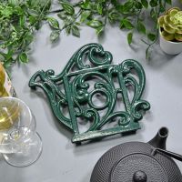 Green Cast Iron Kettle Trivet in Situ on Blue Table
