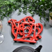 Red Cast Iron Kettle Trivet in Situ on Blue Table